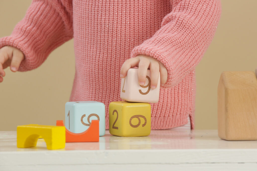 toddler girl playing with wooden blocks