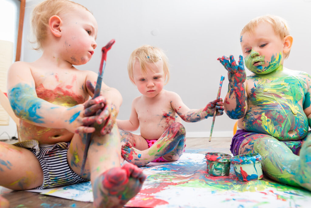 three cute babies playing with vibrant color